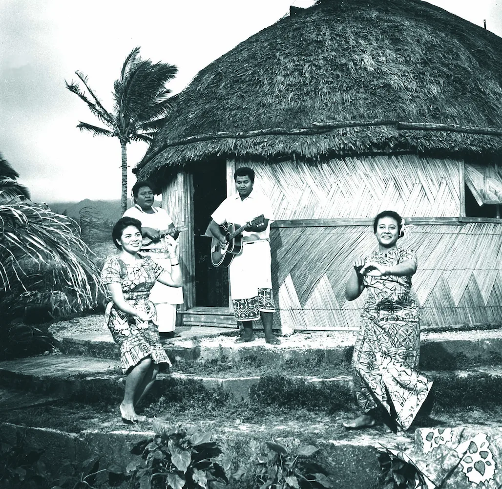 Tongan grass hut with musicians and dancers in native costume.