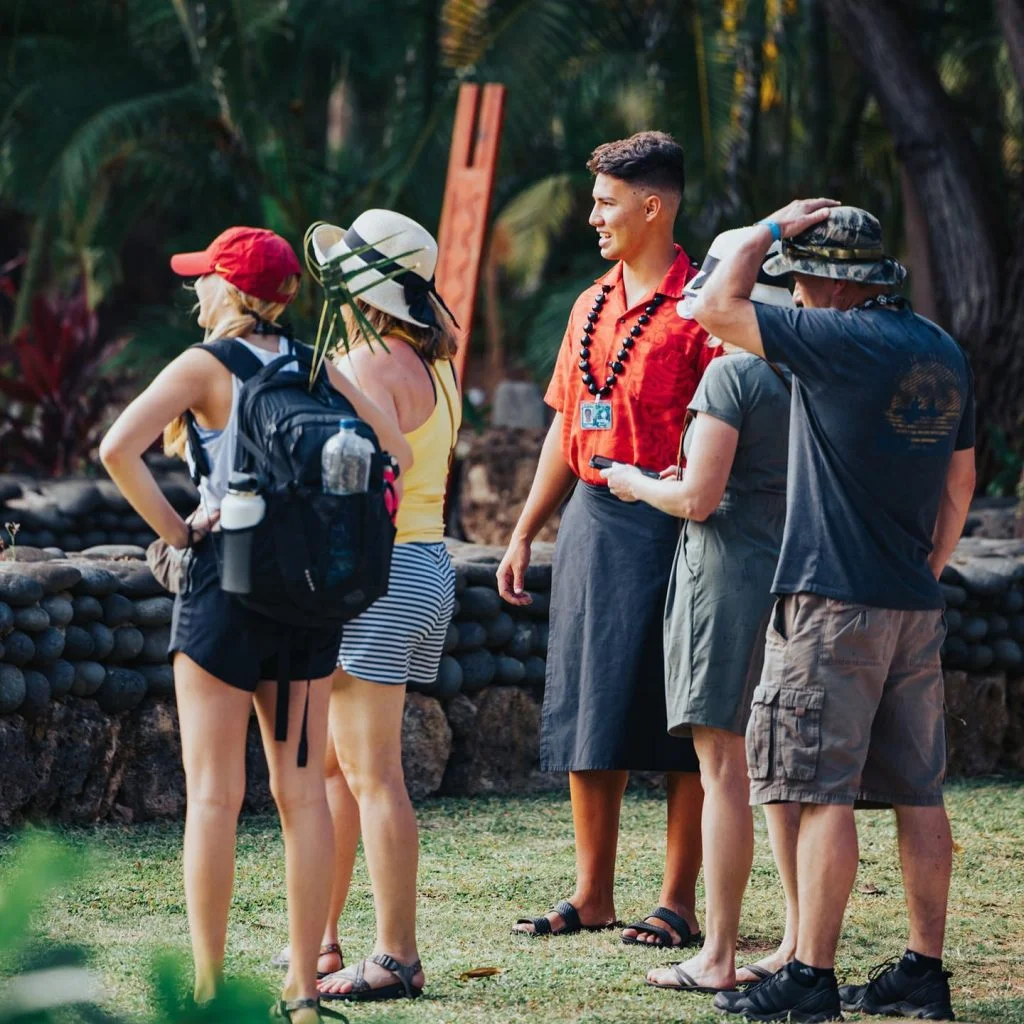 Polynesian guide providing a guided tour of the Polynesian Cultural Center to four guests.