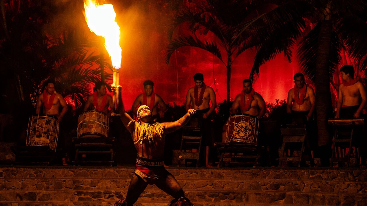  A competitor at the Polynesian Fireknife dancer performing at the 27th Annual Fireknife Competition with drummers playing in the background.