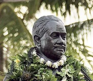 Statue of Prince Kūhiō adorned with lei in Honolulu.