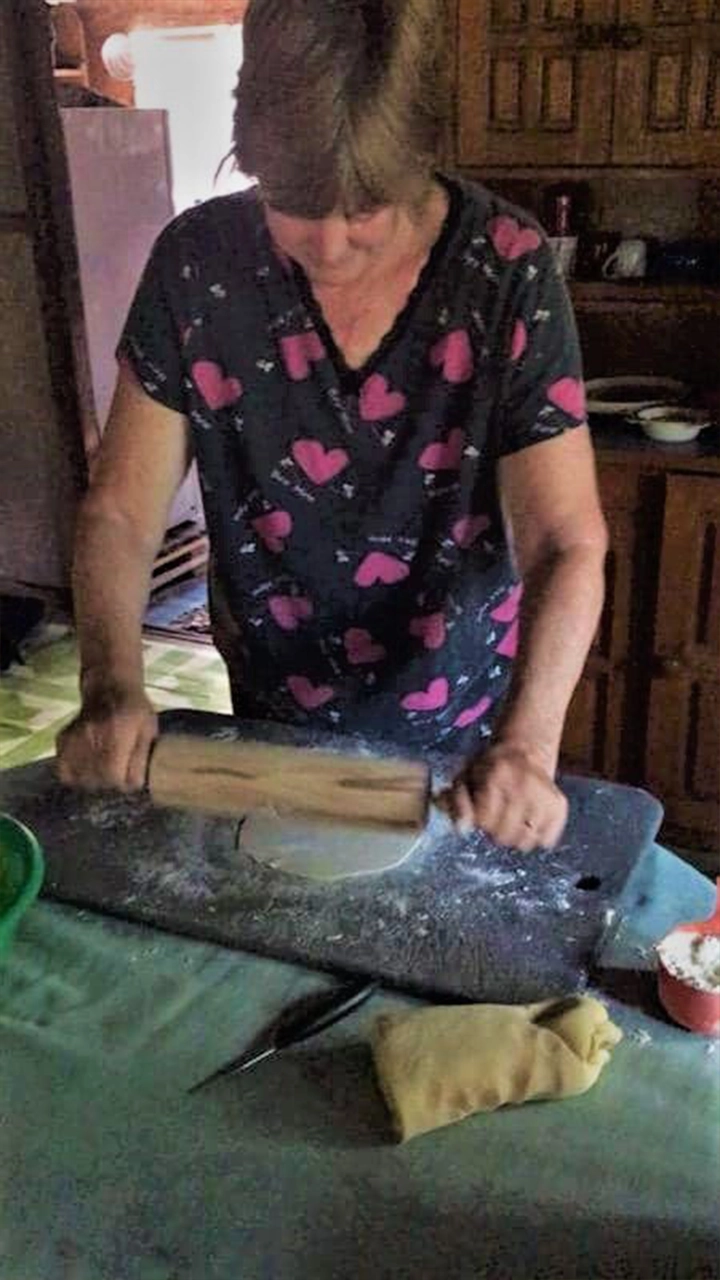 Woman using a rolling pin to make roti, an Indian flat bread popular in Fiji.