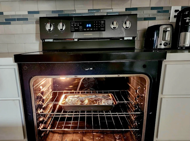 The kalua pork, wrapped in tinfoil, placed in a conventional oven.
