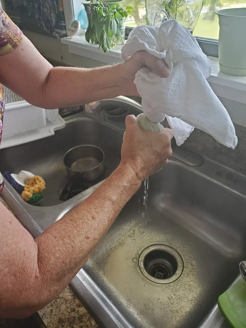 After salting and letting the grated papaya sit to release the moisture, take it and wrap it in cheese cloth or a loose linen towel to remove all water.